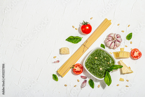 Traditional ingredients for the preparation of classic Italian pasta. Dry spaghetti, basil pesto