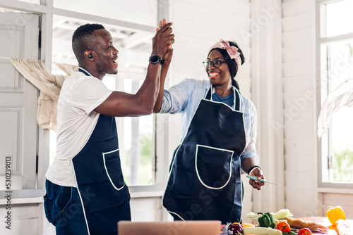 Fotografia Portrait of love african american couple having fun cooking food together with f