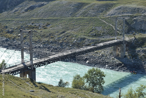 Ininsky Bridge is a suspension bridge over the Katun River near the village of Inya, Ongudaysky district of the Altai Republic, an architectural monument. photo