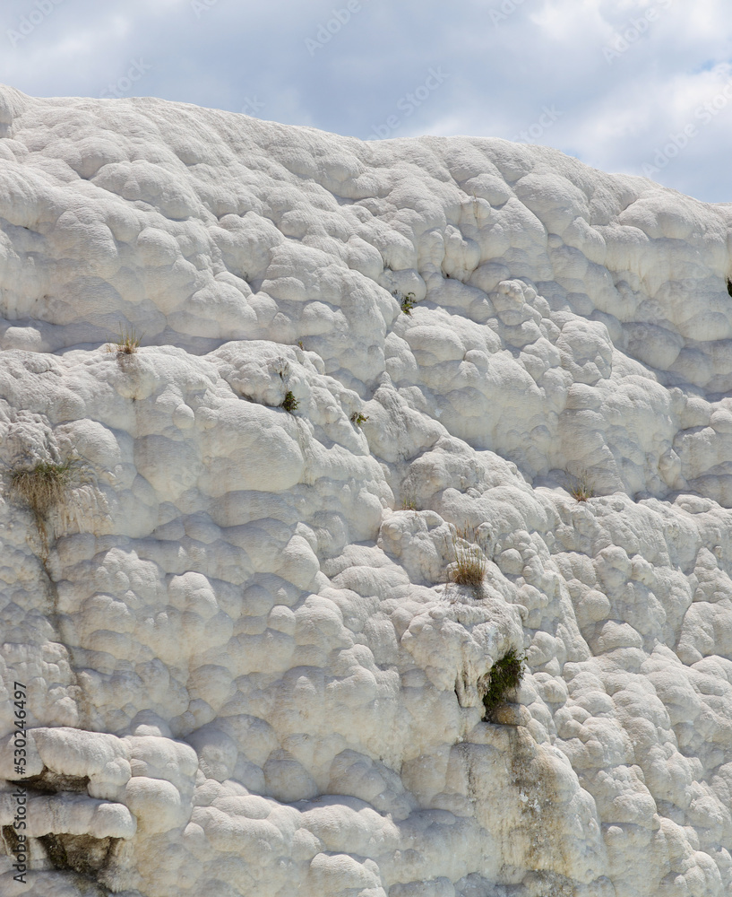 A mountain of white volcanic limestone rock against a blue sky. A mountain of white volcanic limestone rock against a blue sky.
