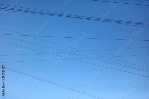 Electric wires against the blue sky. Background