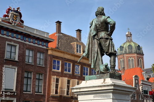 Close-up on the statue of Jan Pieterszoon Coen (1587, 1629), historic houses and the Dome of Koepelkerk church in Hoorn, West Friesland, Netherlands. The statue was unveiled in 1893.