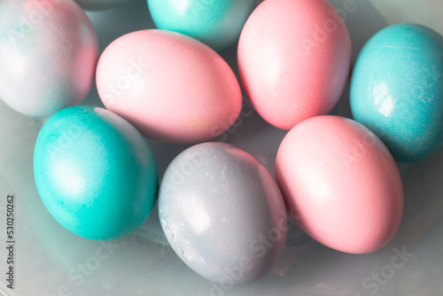 Light pink and turquoise  blue eggs on a blue plate and a gray background for the Easter holiday