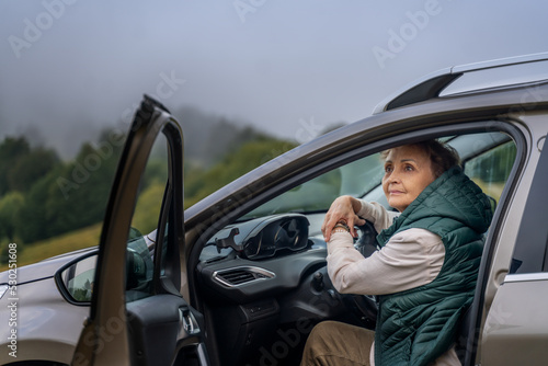 Beautiful happy gray-haired senior mature traveling by car. Active pensioners concept