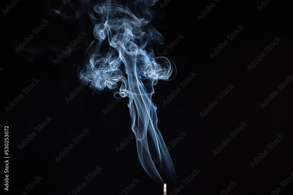 incense stick with smoke against black background incense stick with smoke against black background