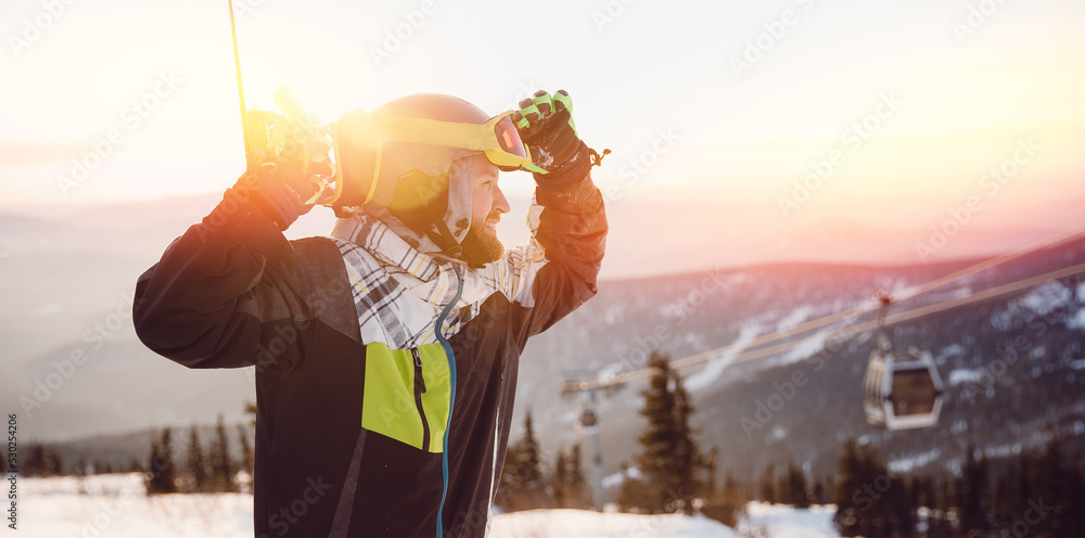 Fototapeta premium Snowboarder man stands background ski resort sunset. Concept banner winter travel, Sheregesh Kemerovo region Russia