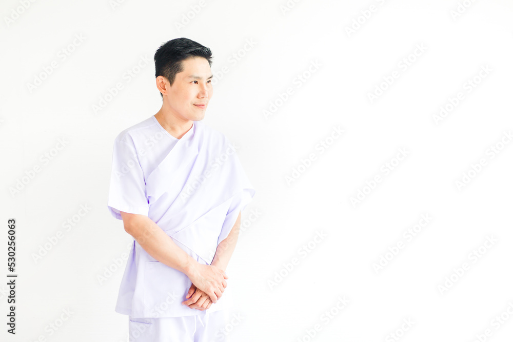 Calm man in white Buddhist costumes meditation and looking out of windows on white background. Asian male worship at home. Copy space Calm man in white Buddhist costumes meditation and looking out of windows on white background. Asian male worship at home. Copy space