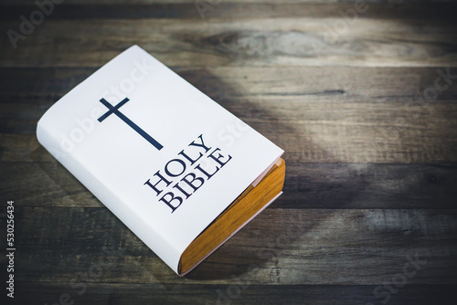 White Holy bible book on wooden table.