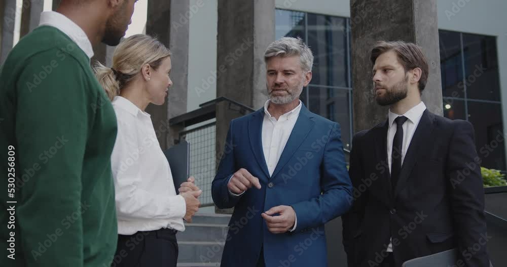 Business People Discussing Near Office On Street. Beautiful Smiling Coworkers Having Conversation Near Building. Business and Corporate Lifestyle Concept Business People Discussing Near Office On Street. Beautiful Smiling Coworkers Having Conversation Near Building. Business and Corporate Lifestyle Concept