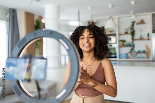 Young female influencer using her smart phone for filming a vlog post.
