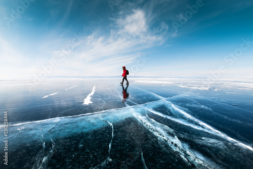 Obraz na płótnie Man tourist walking on the ice of Baikal lake. Winter landscape of Baikal lake, Russia w salonie