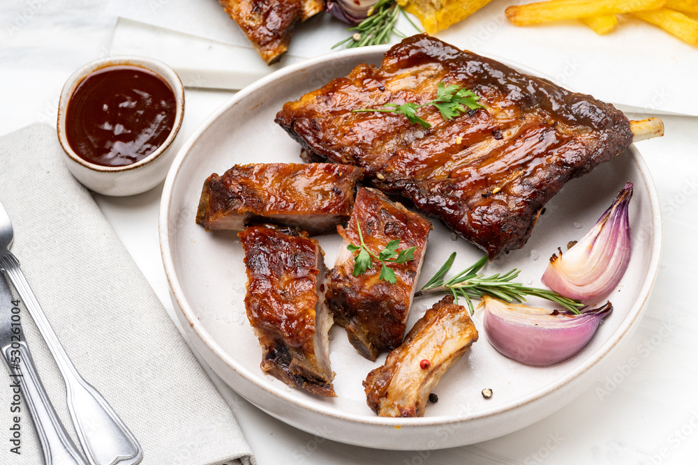 Grilled pork ribs with barbecue sauce and ketchup and grilled vegetables