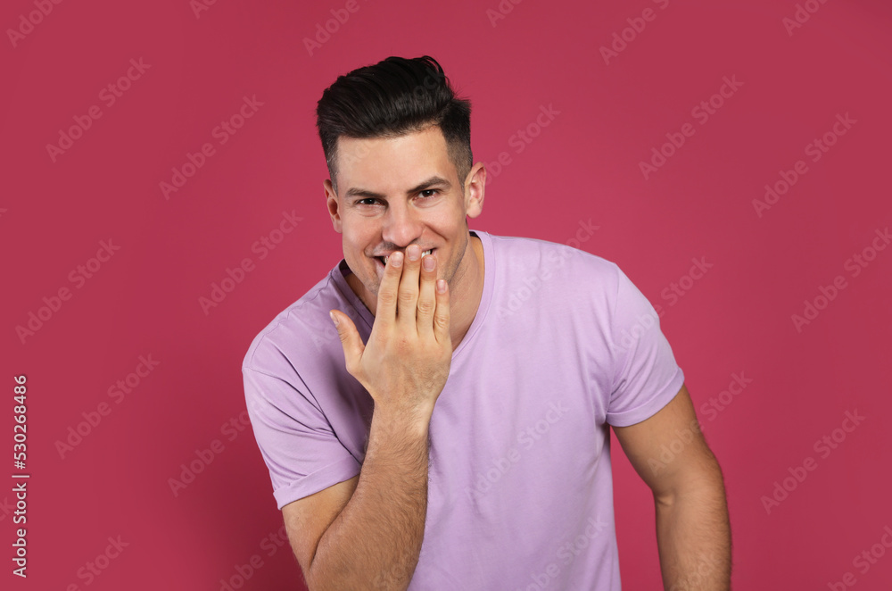 Handsome man laughing on maroon background. Funny joke Handsome man laughing on maroon background. Funny joke