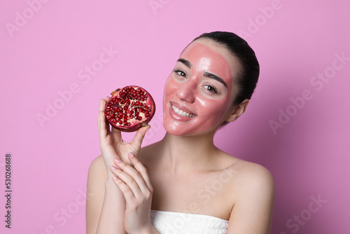 Woman with pomegranate face mask and fresh fruit on pink background