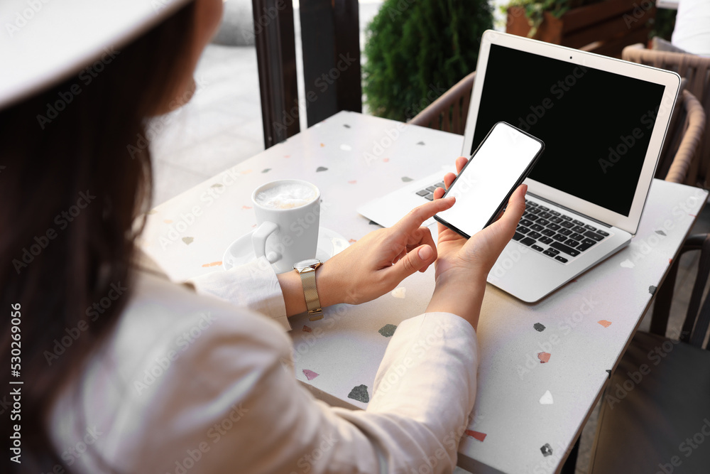 Woman using smartphone in outdoor cafe, closeup Woman using smartphone in outdoor cafe, closeup
