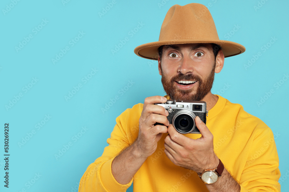 Man with camera on light blue background, space for text. Interesting hobby Man with camera on light blue background, space for text. Interesting hobby