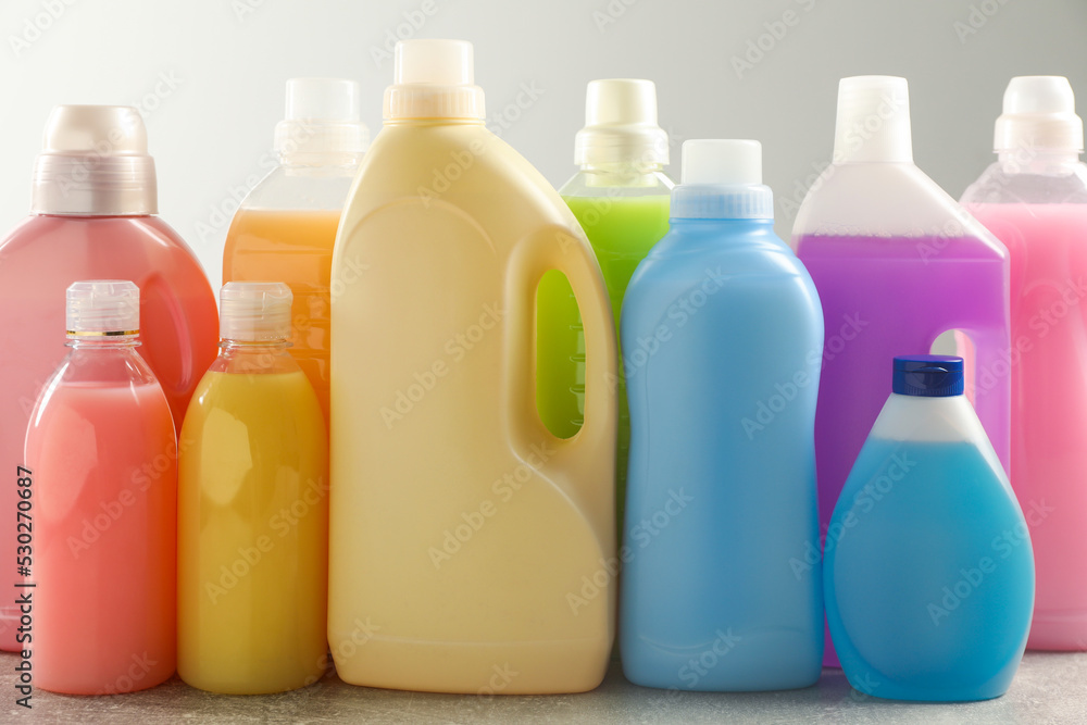 Different bottles with detergents on grey table Different bottles with detergents on grey table