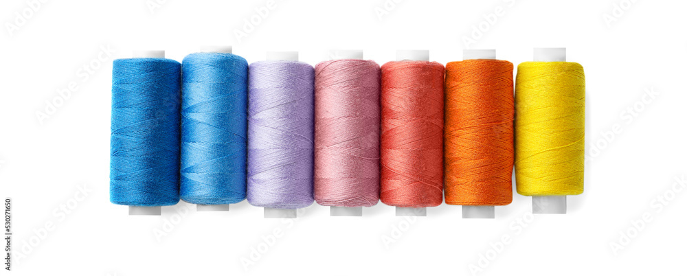 Set of different colorful sewing threads on white background, top view Set of different colorful sewing threads on white background, top view