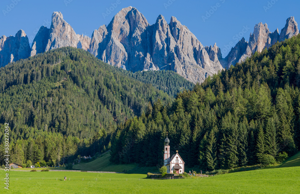 View of San Giovanni (St.John) Church in Ranui in Funes with the Odle mountains group on the background, South Tyrol, Italy
