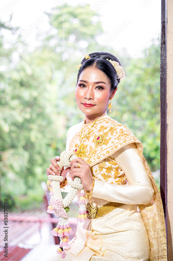 Beautiful asian woman with Thai traditional costume holding garland