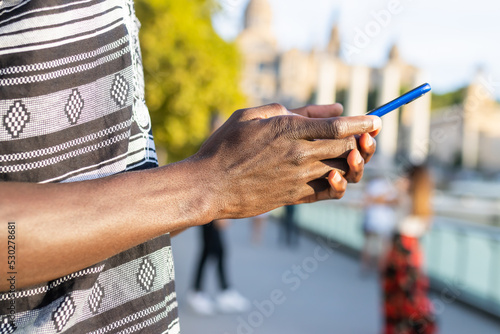 Close-up of the hands of an unrecognizable black man using a cell phone in Barcelona  Spain .