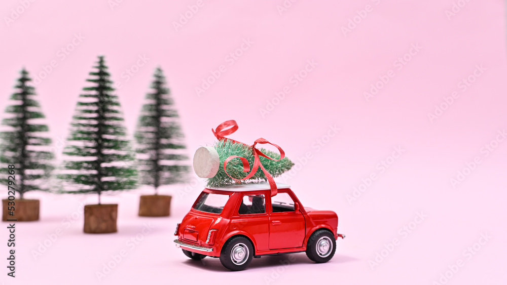 Cute red car with Christmas tree on the roof. Creative New year winter holidays concept background Cute red car with Christmas tree on the roof. Creative New year winter holidays concept background