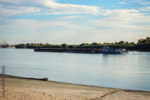 Cargo barge sails to the port  Blue sky