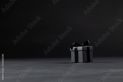 Composition of present with black ribbon on gray background