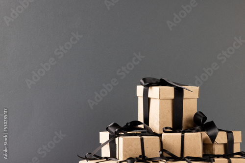 Composition of presents with black ribbons on gray background