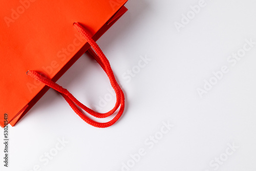 Composition of red paper shopping bag on white background