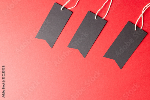 Composition of gift tags with copy space on red background