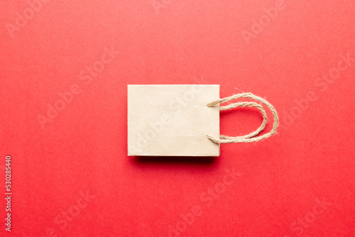 Composition of white paper shopping bag on red background