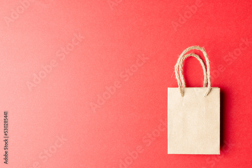 Composition of gray paper shopping bag on red background