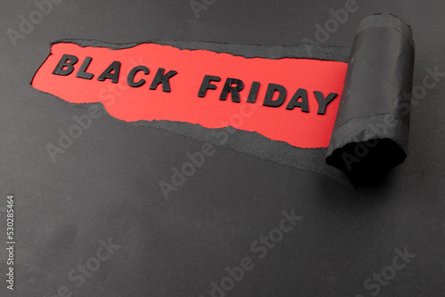 Composition of black paper and black friday text on red background