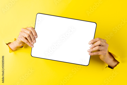 Composition of hands holding board with copy space on yellow background