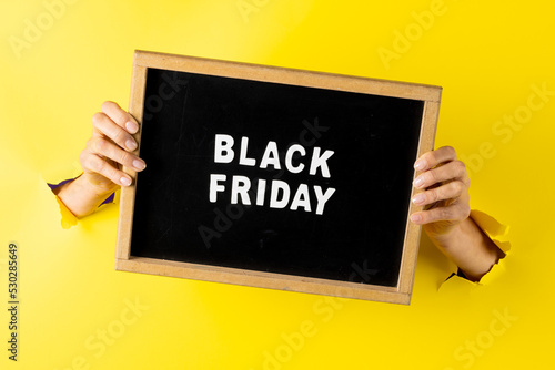 Composition of hands with black friday text on yellow background