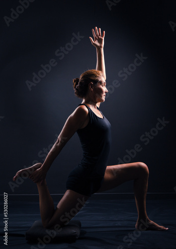 Fototapeta Naklejka Na Ścianę i Meble -  Adult woman in yoga posture in low key