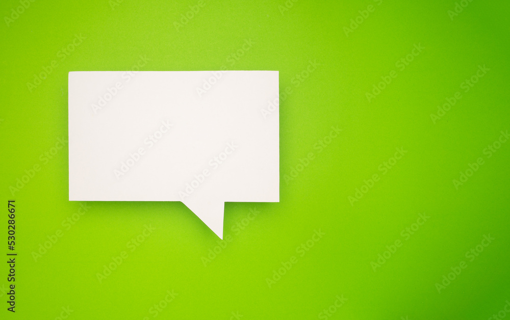 A blank white speech bubble over a light green background A blank white speech bubble over a light green background