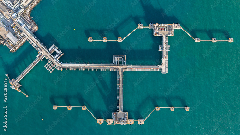 Aerial top view oil terminal station platform with loading arm pipe line on deep seaport, Oil storage terminal port. - obrazy, fototapety, plakaty 
