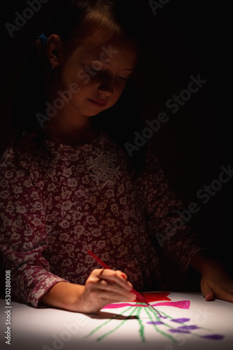 Happy young girl in art studio painting picture. Selective focus on eyes of child. Vertical image.