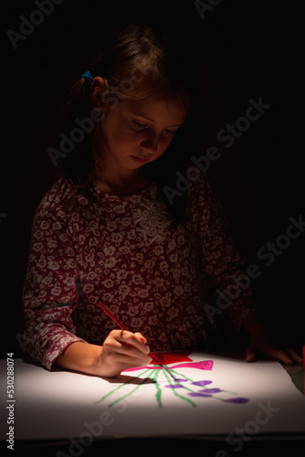 No face portrait of child girl painting on paper.  Selective focus on eyes of child.