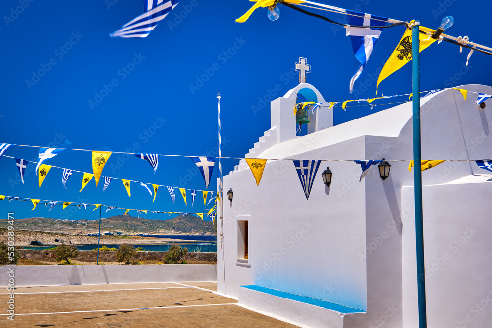 White Greek Orthodox chapel or church on top of hill against clear