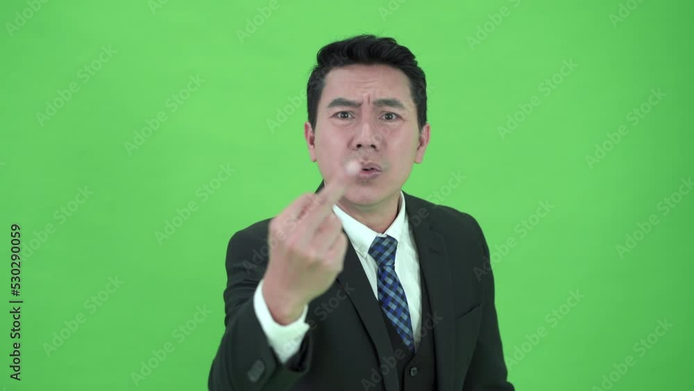 Asian businessman showing a middle finger hand sign on chroma green screen. Asian businessman showing a middle finger hand sign on chroma green screen.