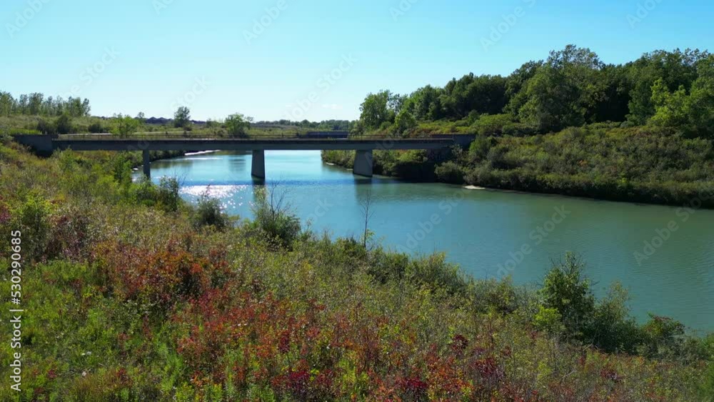 Aerial shot of inspiring colorful natural scenery surrounding bridge over river Aerial shot of inspiring colorful natural scenery surrounding bridge over river