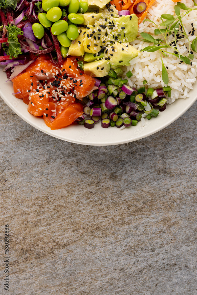 Close up of hawaiian poke bowl in white bowl on grey background Close up of hawaiian poke bowl in white bowl on grey background
