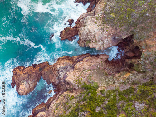 High angle view of sea waves and sea shore with rocky cliff shore