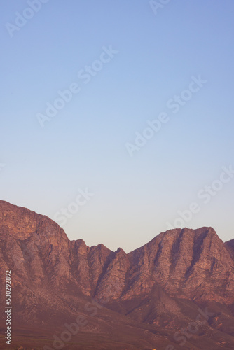 Landscape of rocky mountains with stones and pebbles against cloudless blue sky
