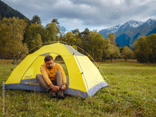 trip to Caucasus mountains  Arkhyz  Teberdinsky reserve. Man traveler relaxing in mountains in tent camping outdoor Travel adventure lifestyle concept hiking active vacations.