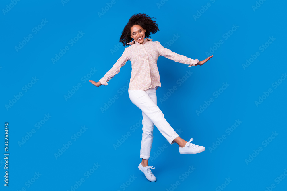 Fototapeta premium Full length portrait of active energetic cheerful girl jump have good mood isolated on blue color background
