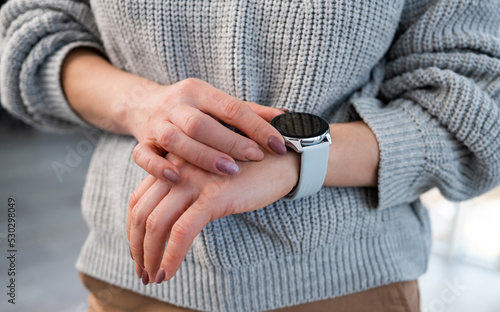 Person with smart watch on hand looking at time on digital screen with copy space. Girl with innovative electronic clock
